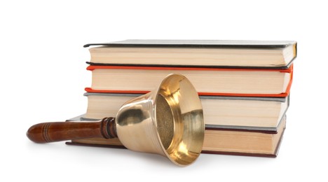 Photo of Golden school bell with wooden handle and stack of books on white background