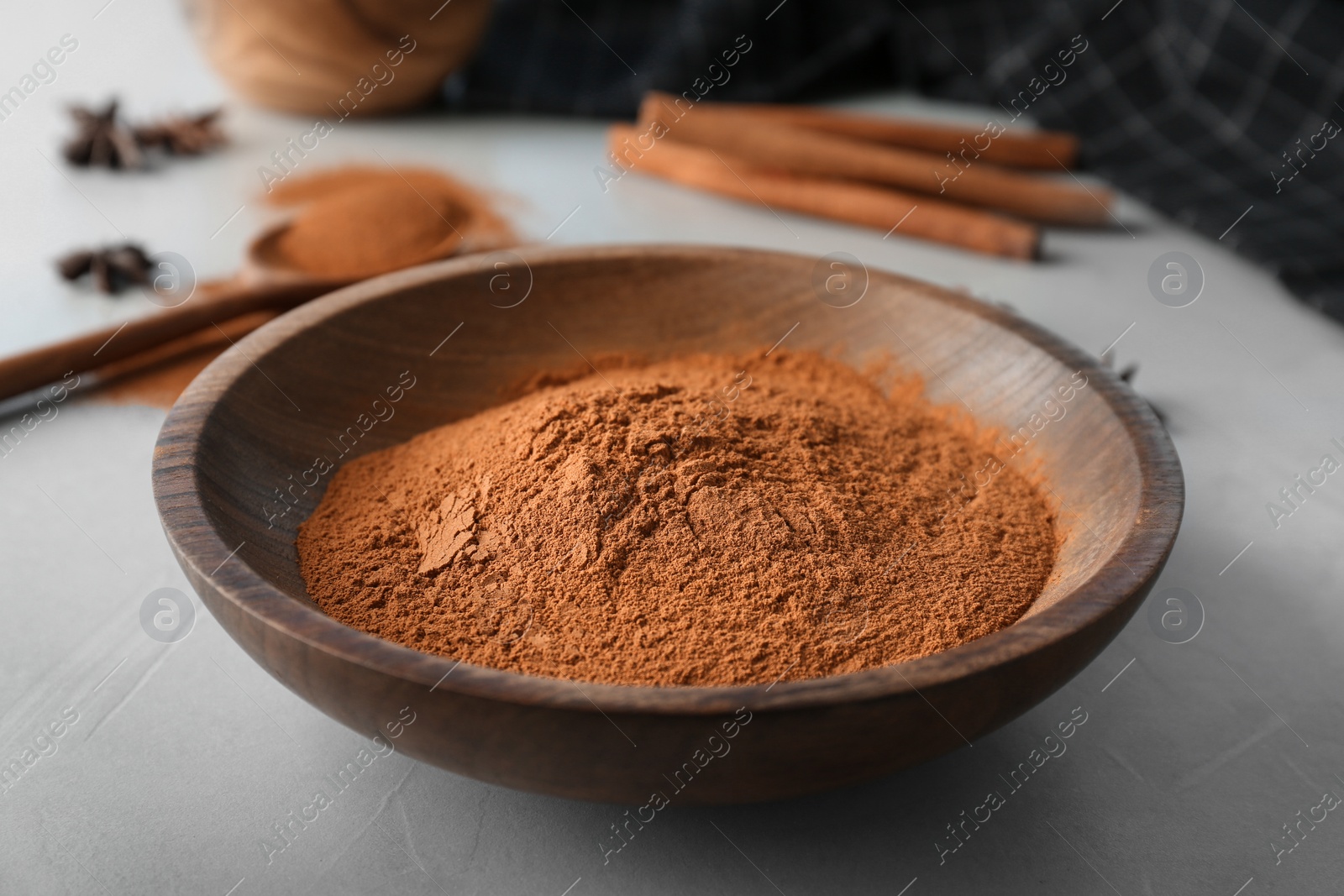 Photo of Bowl with aromatic cinnamon powder on table