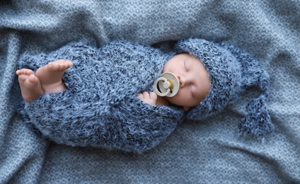 Cute newborn baby sleeping on blanket, top view