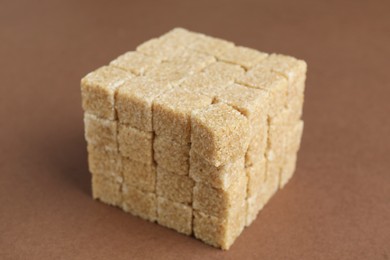 Brown sugar cubes on color background, closeup