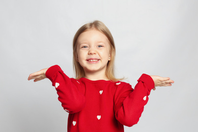 Photo of Portrait of cute funny little girl on light grey background