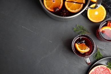 Photo of Flat lay composition with tasty mulled wine on black table. Space for text