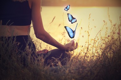 Young woman meditating near river at sunset, closeup