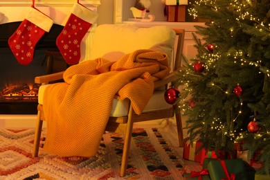 Living room interior with fireplace, armchair and Christmas decor