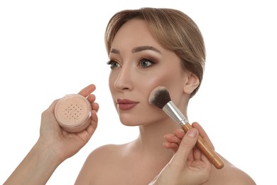 Photo of Professional makeup artist applying powder onto beautiful young woman's face with brush on white background