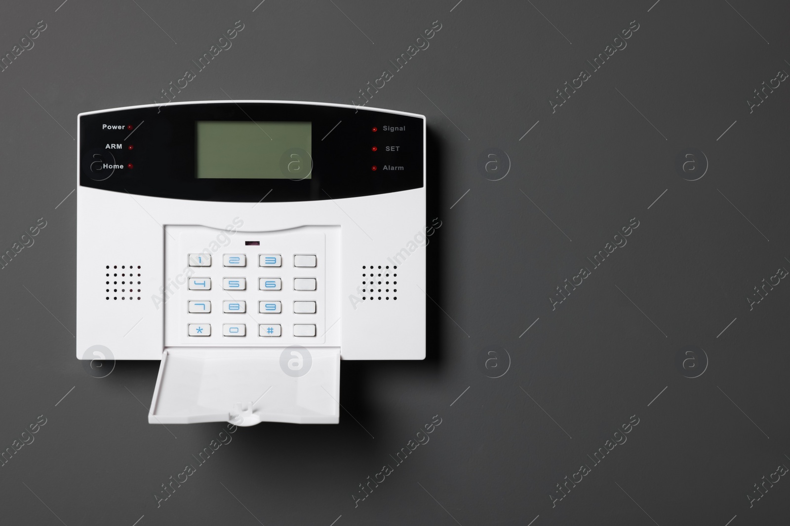 Photo of Home security alarm system on gray wall, space for text