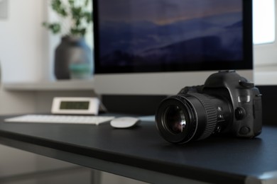 Photo of Professional camera and computer on table in photo studio, space for text. Interior design