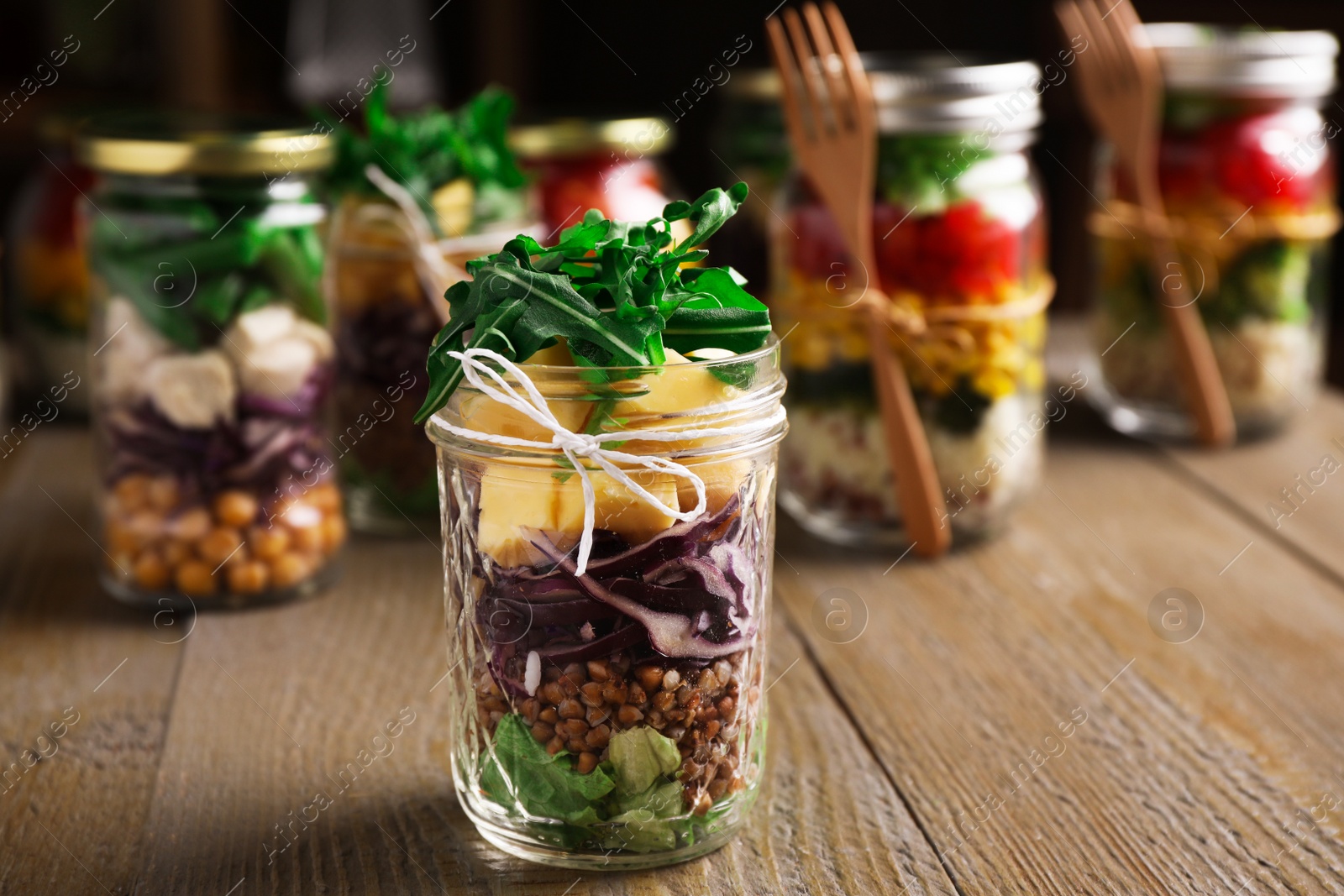 Photo of Glass jar with healthy meal on wooden table