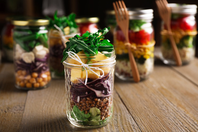 Photo of Glass jar with healthy meal on wooden table