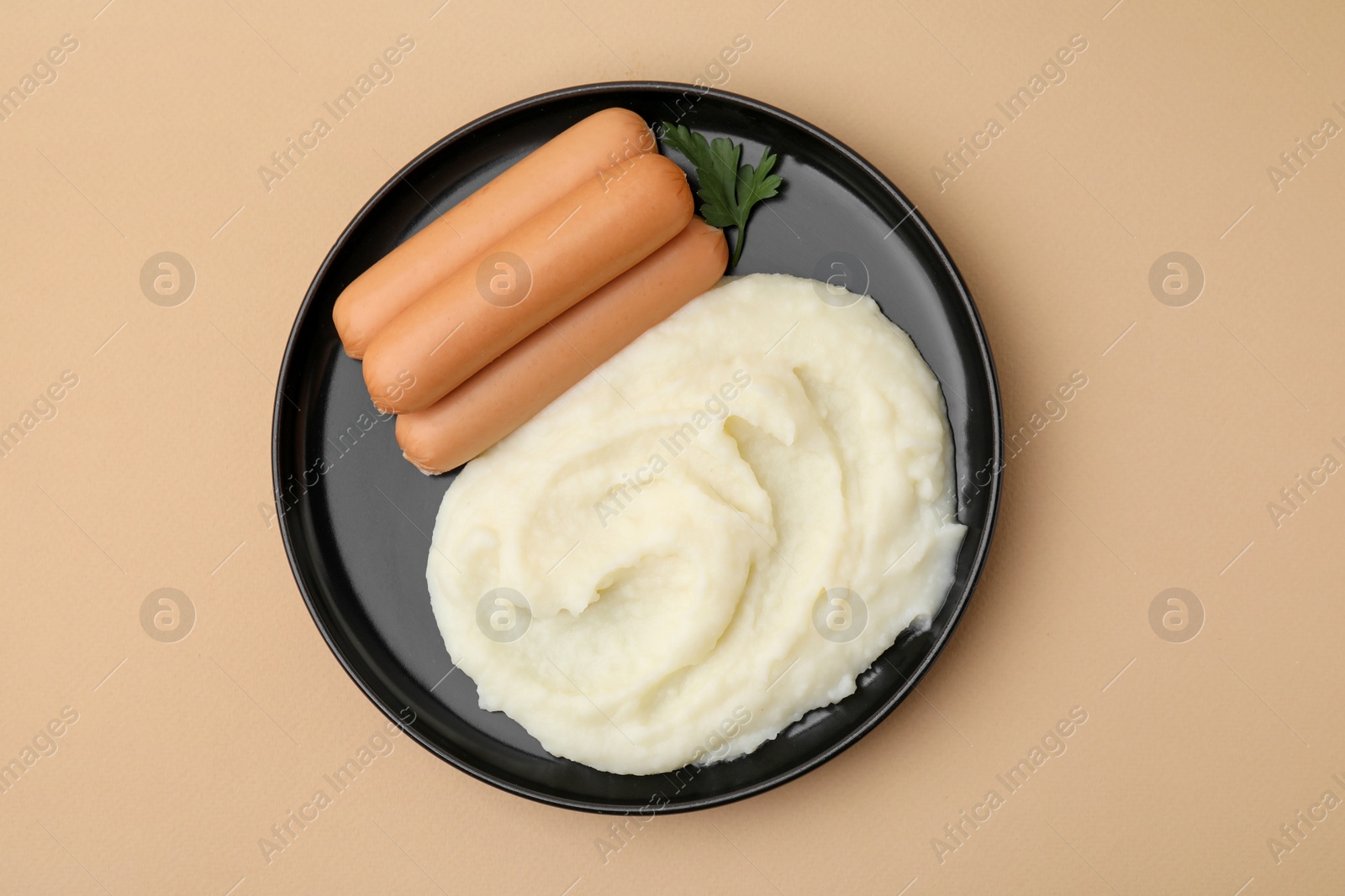 Photo of Delicious boiled sausages, mashed potato and parsley on beige background, top view