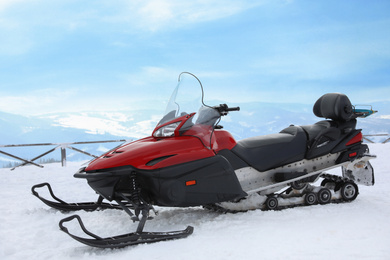 Photo of Modern snowmobile on hill at mountain ski resort