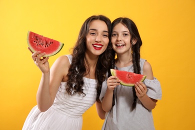 Photo of Happy girls with watermelon on yellow background