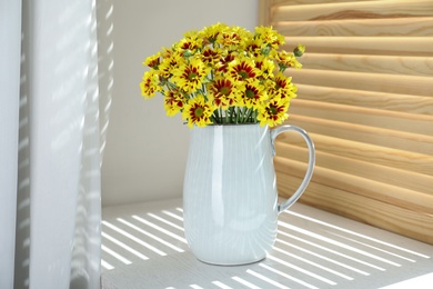 Vase with beautiful chrysanthemum flowers on white windowsill