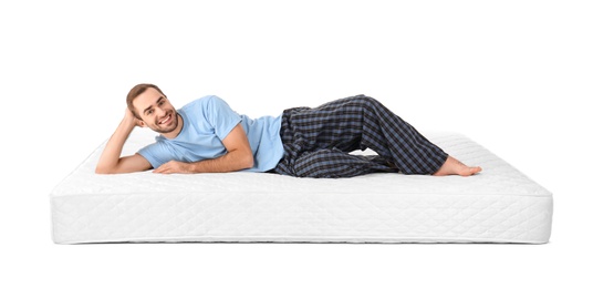 Photo of Young man lying on mattress against white background