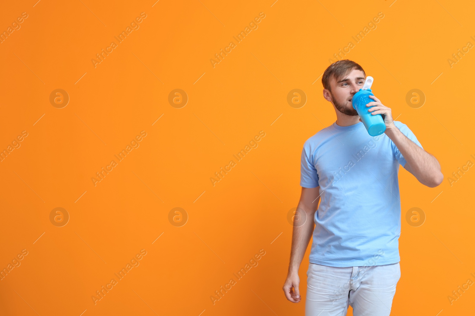 Photo of Young man with bottle of delicious milk shake on color background