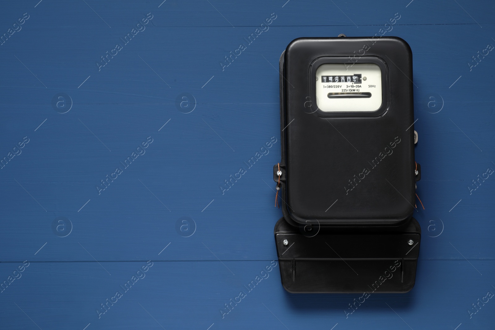 Photo of Electricity meter on blue wooden wall, space for text