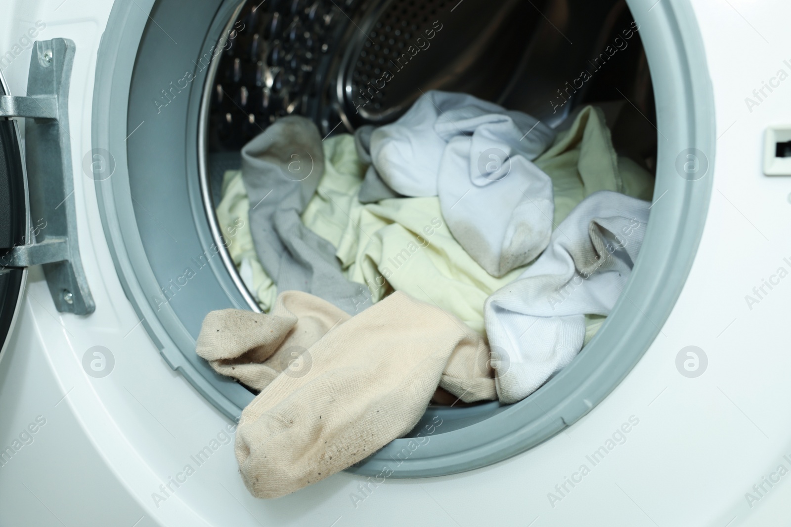 Photo of Many dirty socks in washing machine, closeup