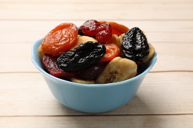 Photo of Mix of delicious dried fruits on white wooden table, closeup