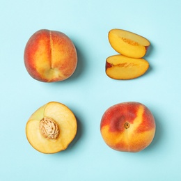 Sweet juicy peaches on light blue background, flat lay