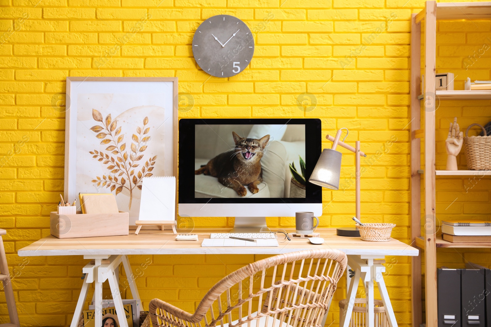 Photo of Stylish home office interior with comfortable workplace near yellow brick wall