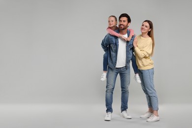 Happy family on light grey background, space for text