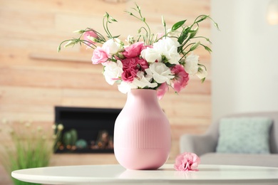Photo of Vase with beautiful flowers on table in living room