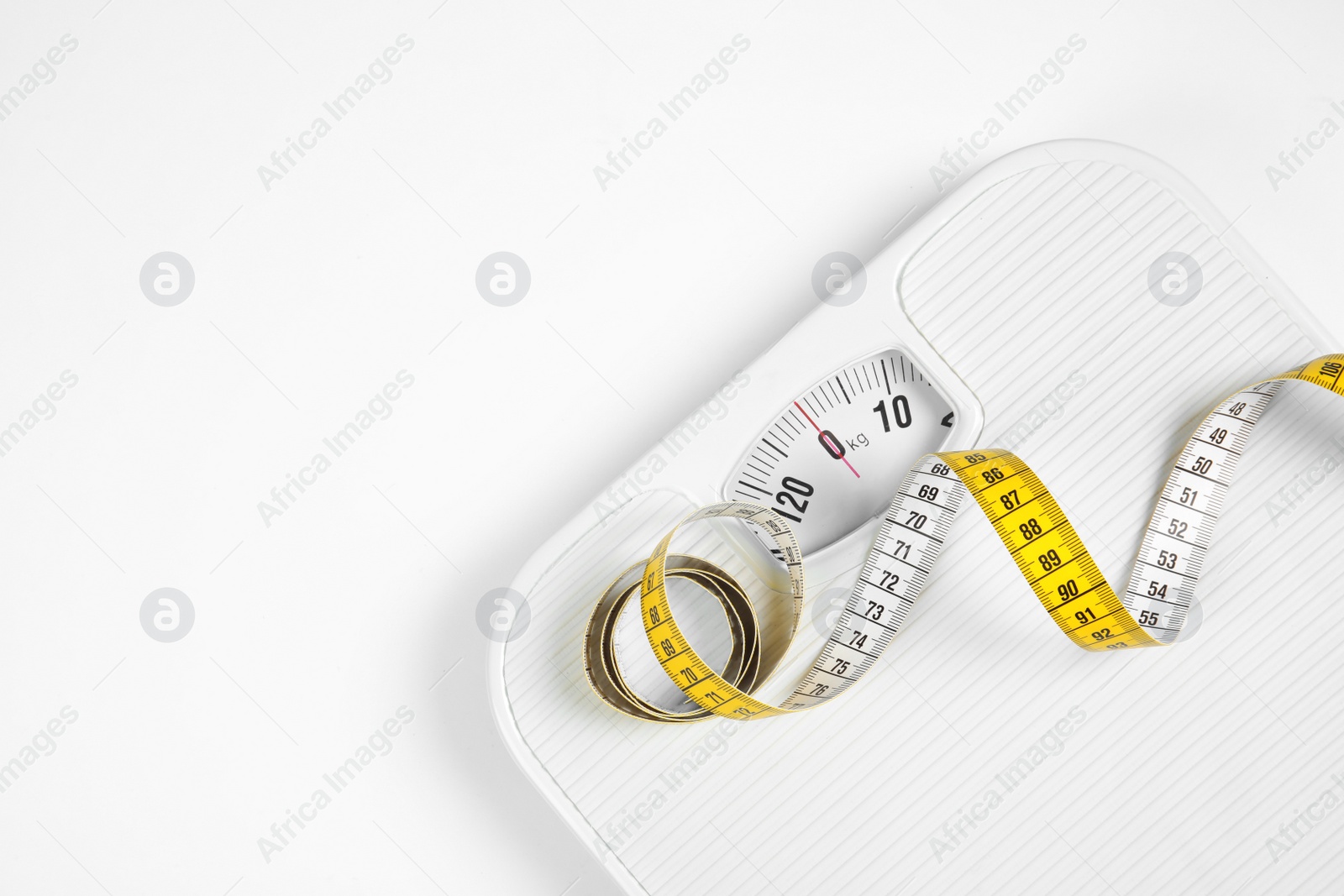 Photo of Modern scales and tape measure isolated on white, top view