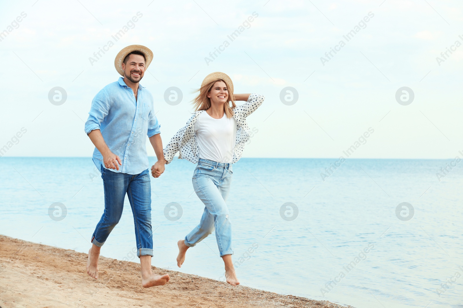 Photo of Happy romantic couple running together on beach, space for text