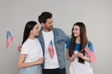4th of July - Independence Day of USA. Happy family with American flags on grey background