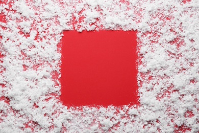 Photo of Frame made of snow on red background, top view with space for text. Winter season