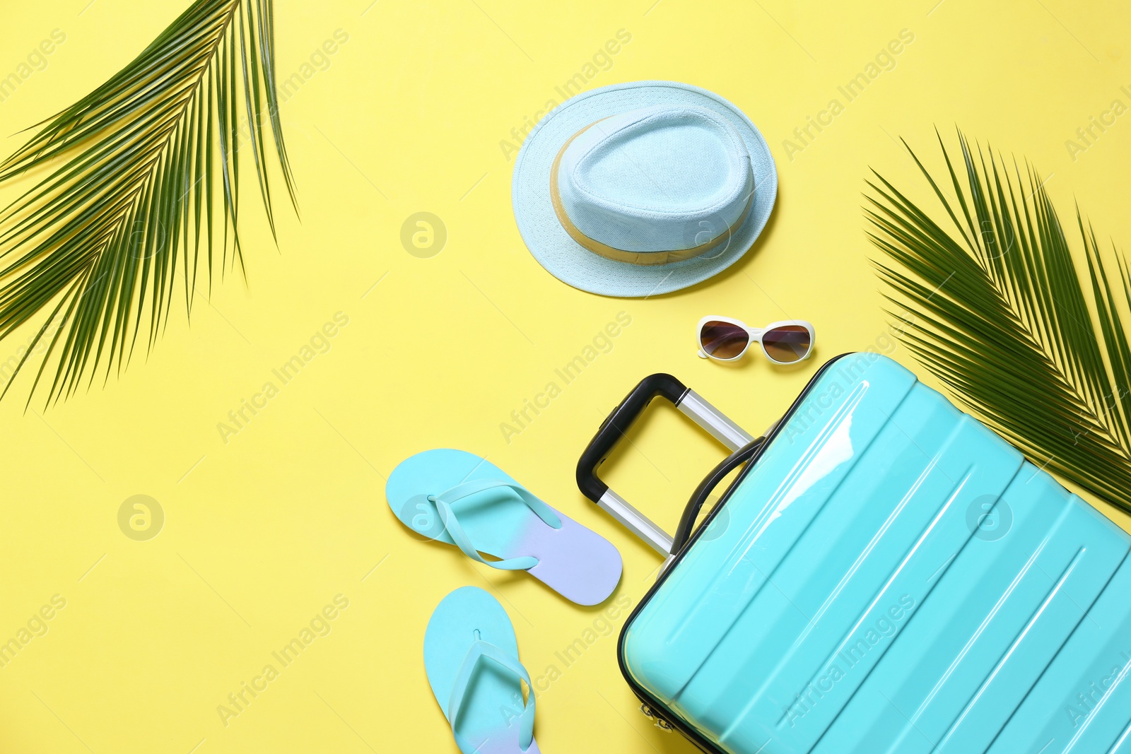 Photo of Flat lay composition with stylish suitcase on yellow background