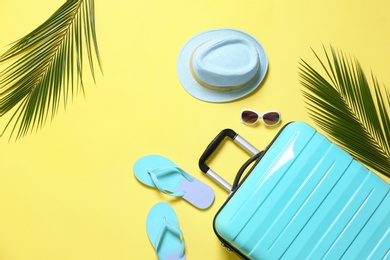 Flat lay composition with stylish suitcase on yellow background