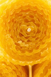 Stylish elegant yellow beeswax candles as background, closeup