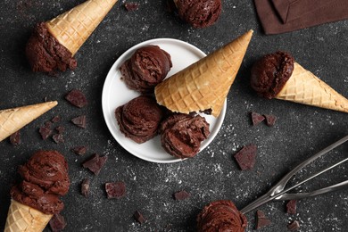 Photo of Flat lay composition with tasty ice cream scoops in waffle cones on dark textured table