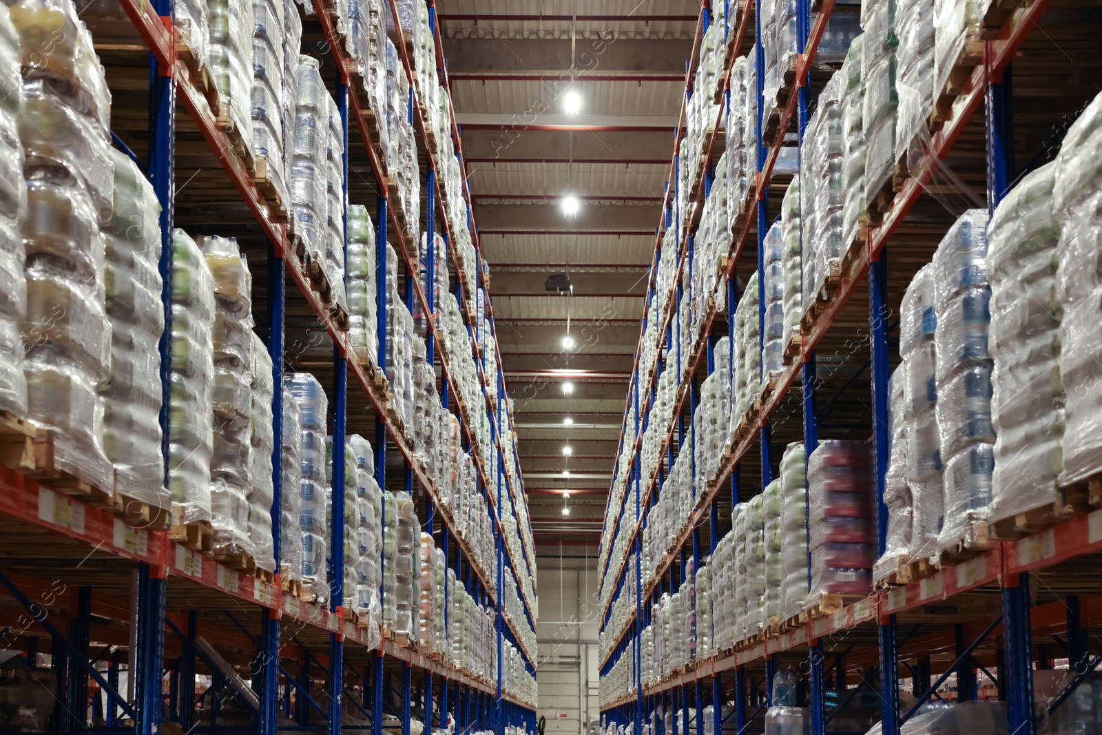 Photo of Warehouse interior with metal racks full of merchandise. Wholesale business