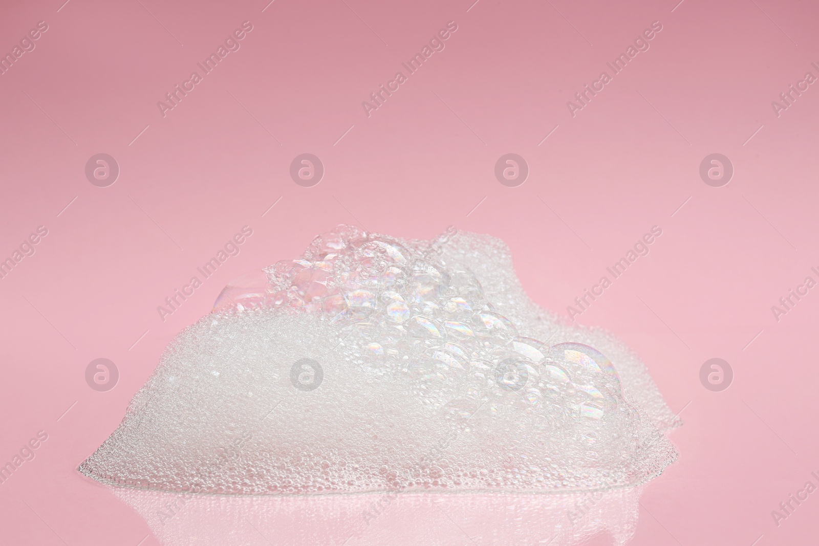 Photo of Drop of fluffy bath foam on pink background