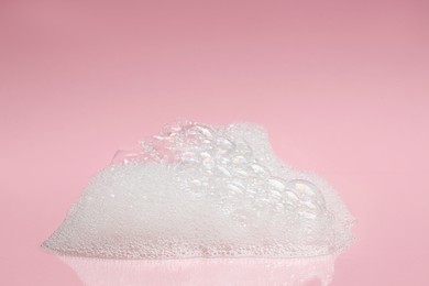 Photo of Drop of fluffy bath foam on pink background