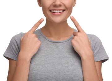 Woman pointing at her clean teeth and smiling on white background, closeup