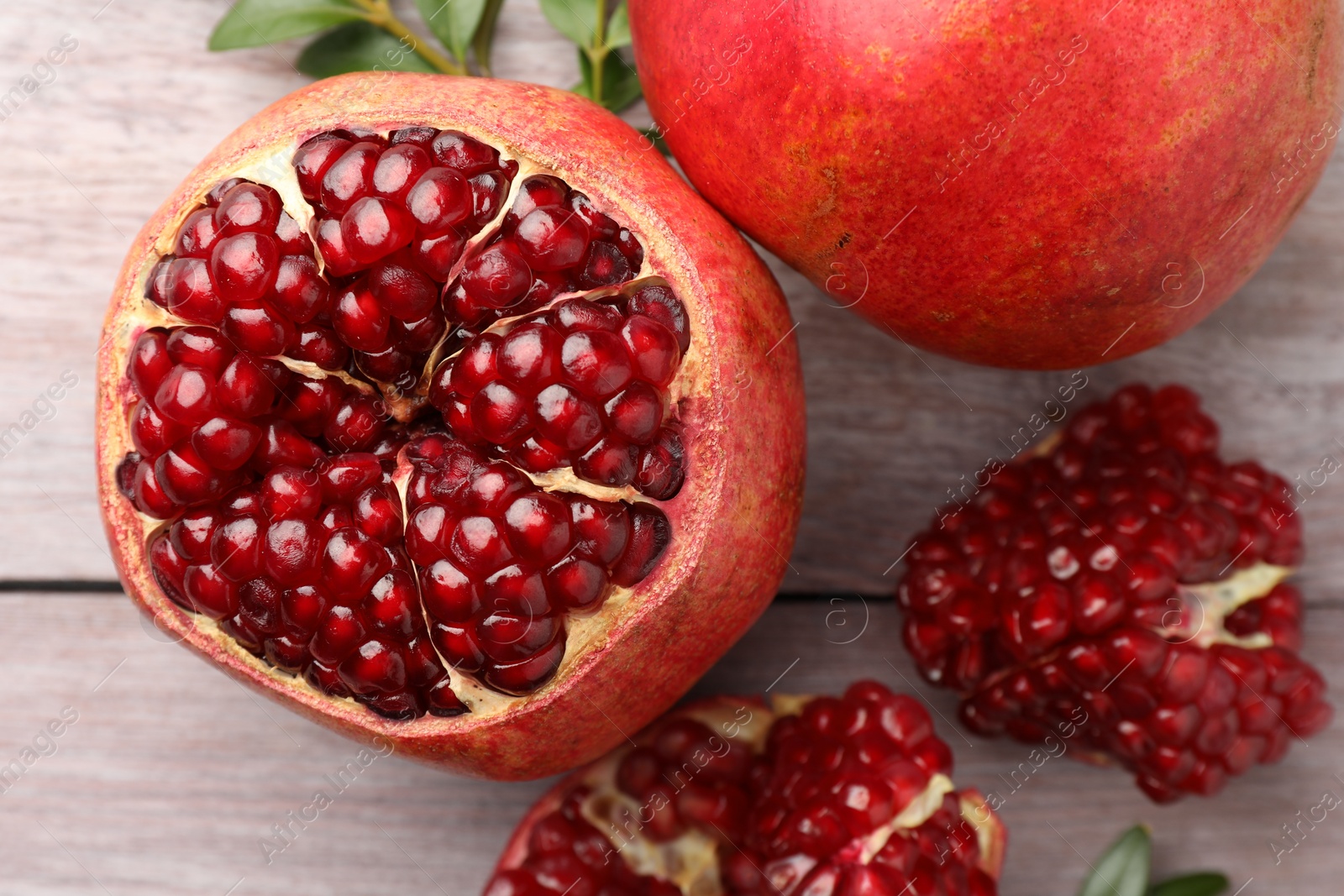 Photo of Fresh pomegranates on wooden table, top view