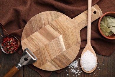 Photo of Cooking utensils with different spices on wooden table, flat lay