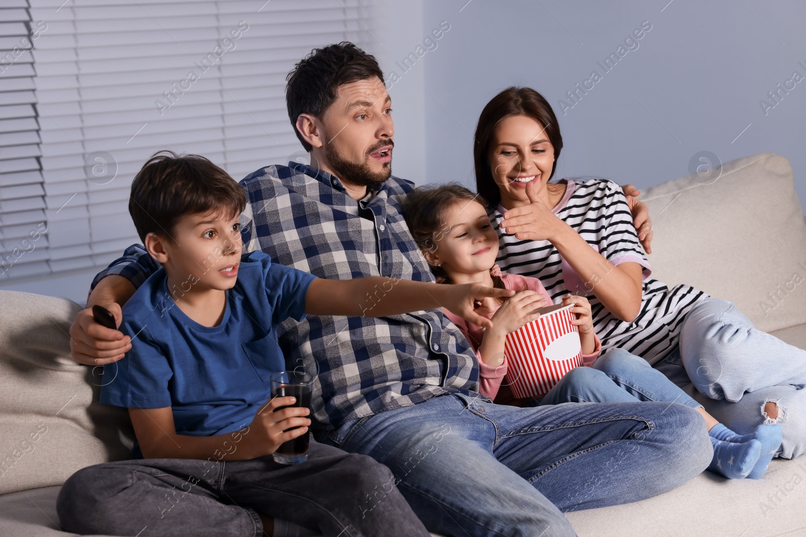 Photo of Family watching TV at home in evening