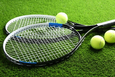 Photo of Tennis rackets and balls on green grass. Sports equipment