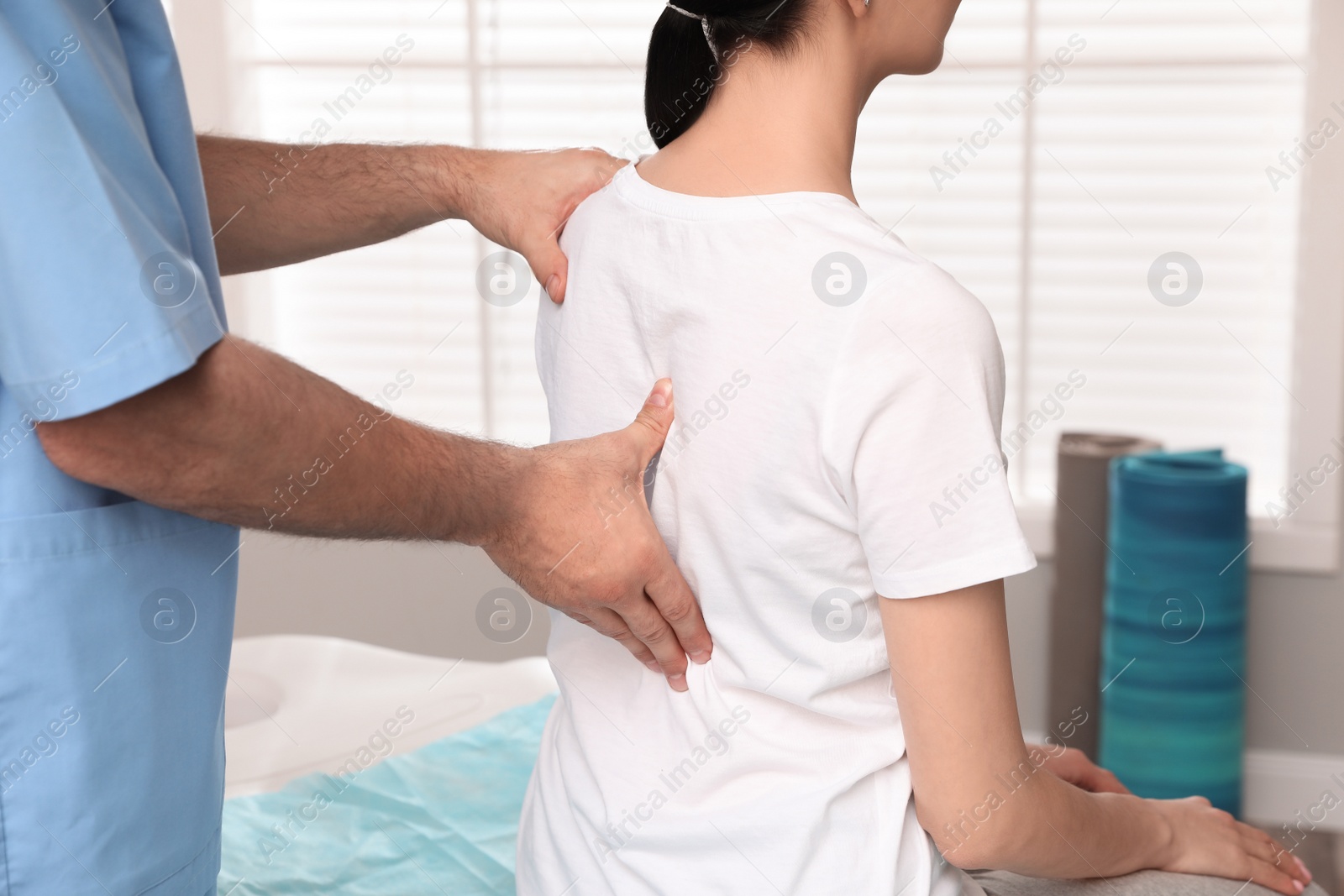 Photo of Orthopedist examining woman's back in clinic, closeup. Scoliosis treatment