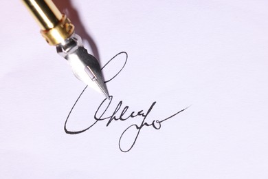 Photo of Signing on sheet of paper with fountain pen, closeup