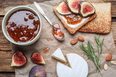 Photo of Flat lay composition with delicious fig jam on wooden table