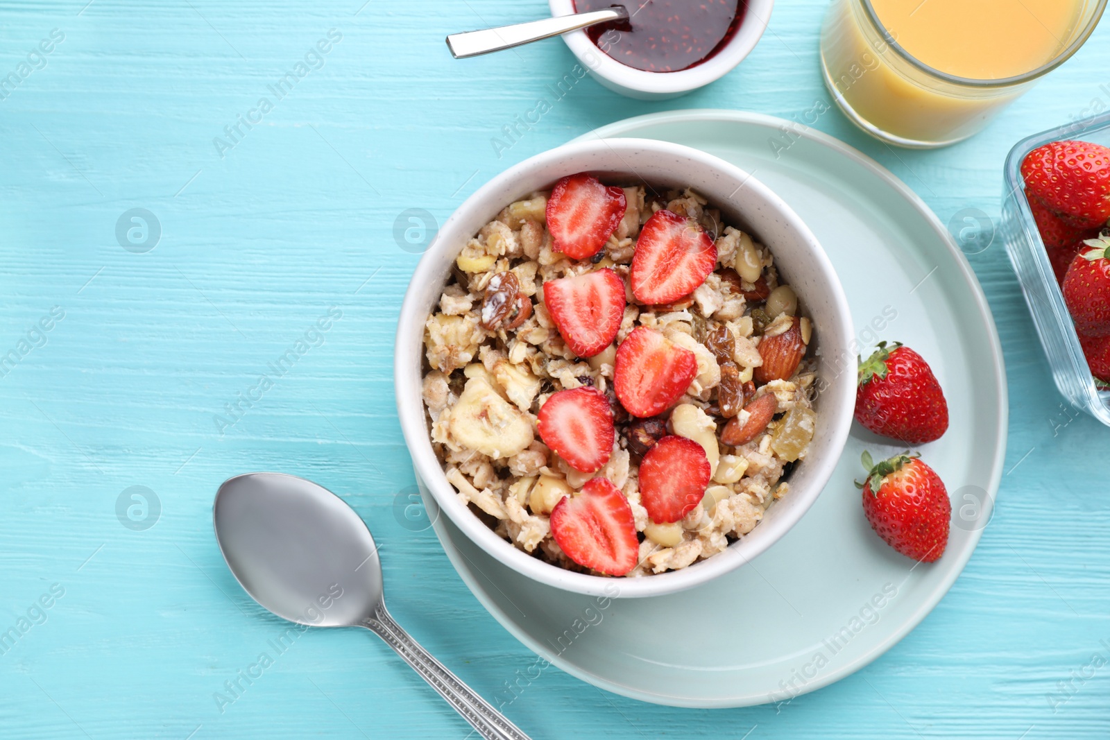 Photo of Flat lay composition with tasty muesli on light blue wooden table. Healthy breakfast