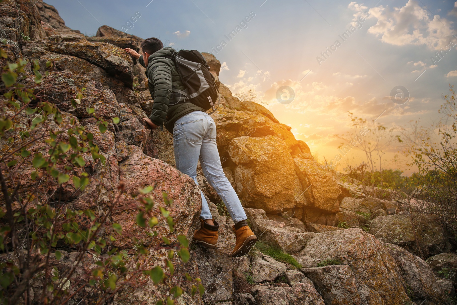 Photo of Hiker with backpack climbing up mountain on autumn day