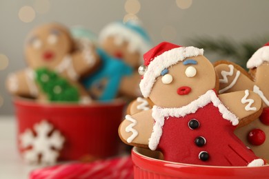 Delicious homemade Christmas cookies in bowl against blurred festive lights, closeup. Space for text