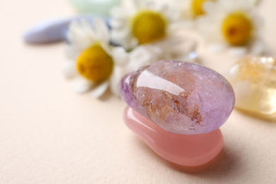 Photo of Beautiful gemstones on beige table, closeup. Healing crystals