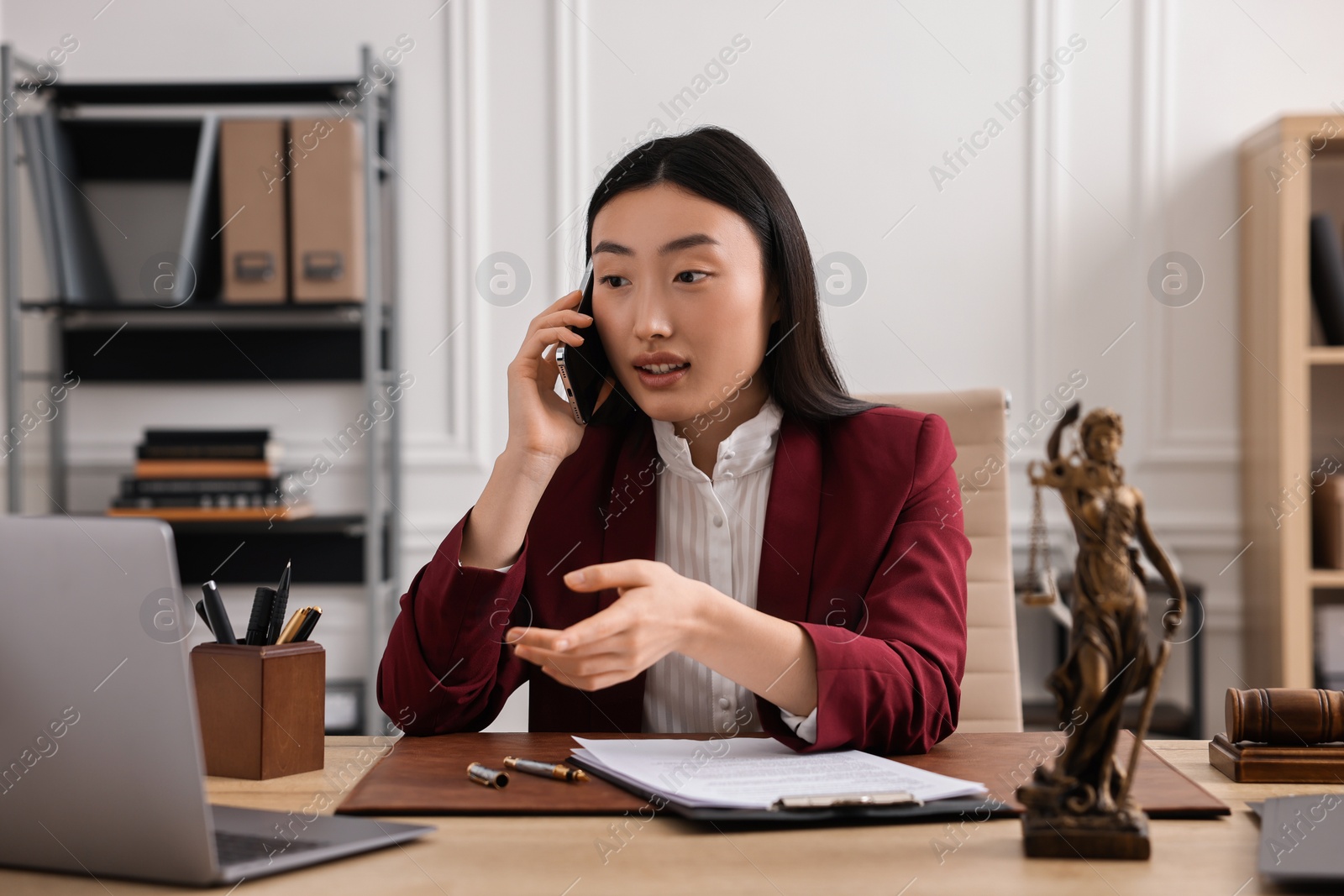 Photo of Notary talking on phone at table in office